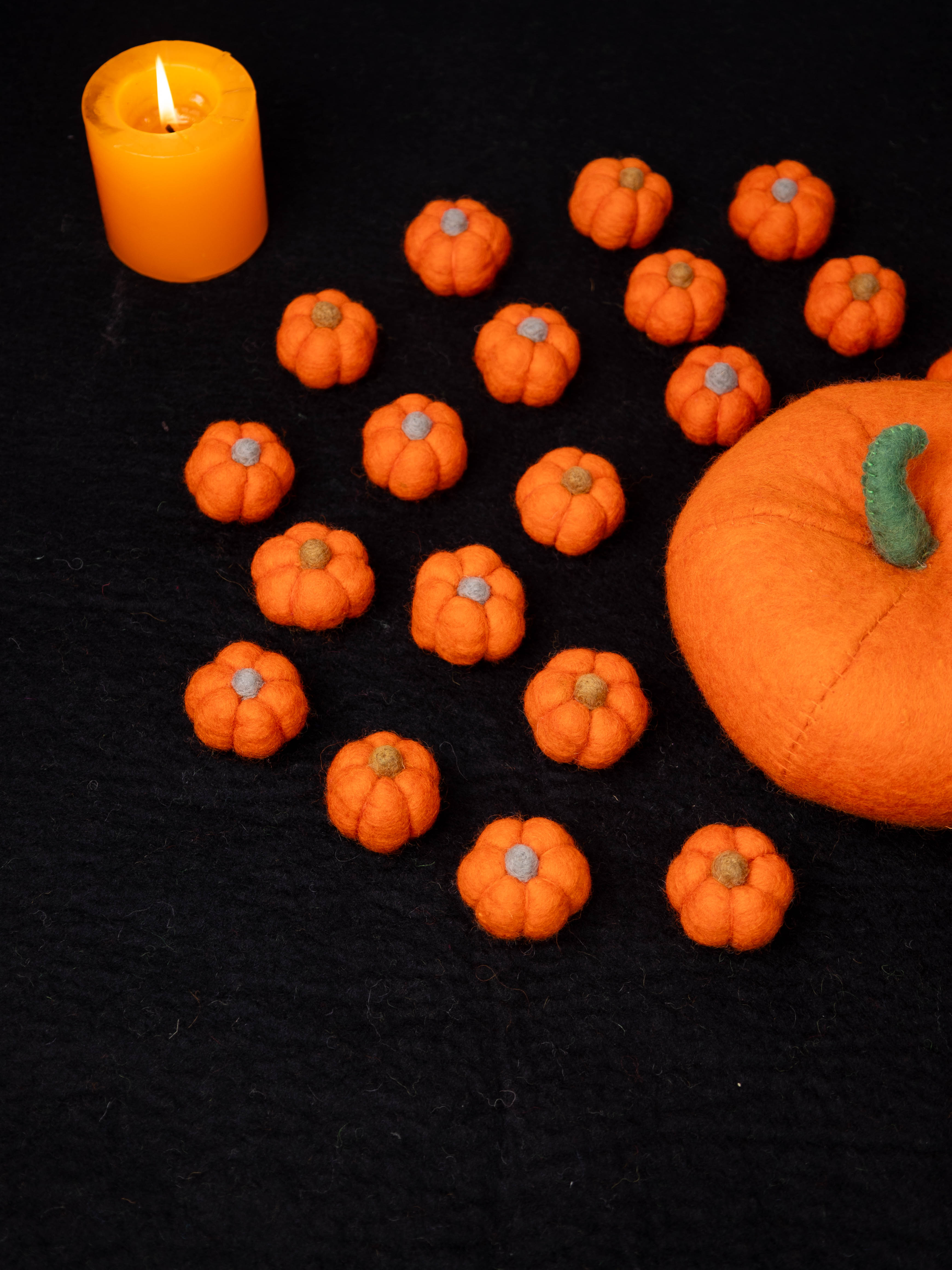 Felt Halloween decorations including pumpkins for seasonal retail collections.